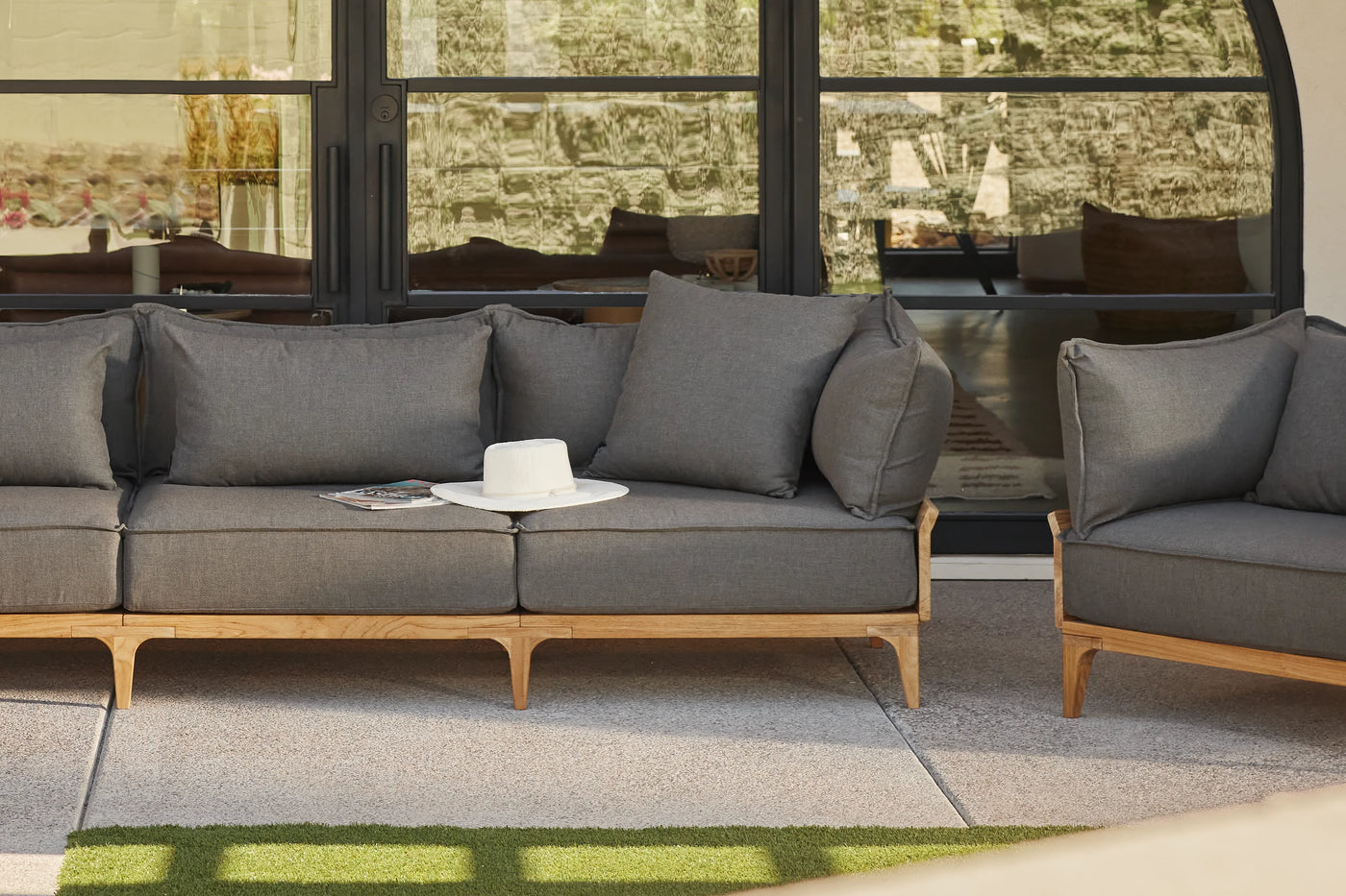 Neighbor outdoor sofa and lounge chair on a shaded patio.